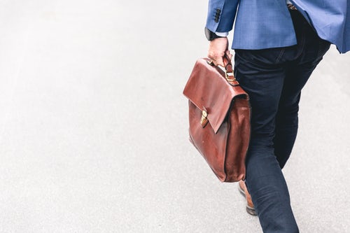 man carrying brown bag to a conference