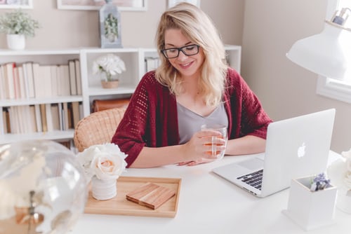 Young lady taking coffee while working