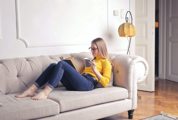 lady on her couch reading on earning from Chatgpt