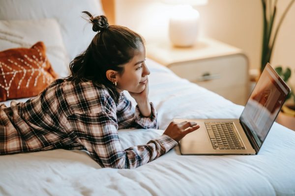 Girl browsing on her bed 